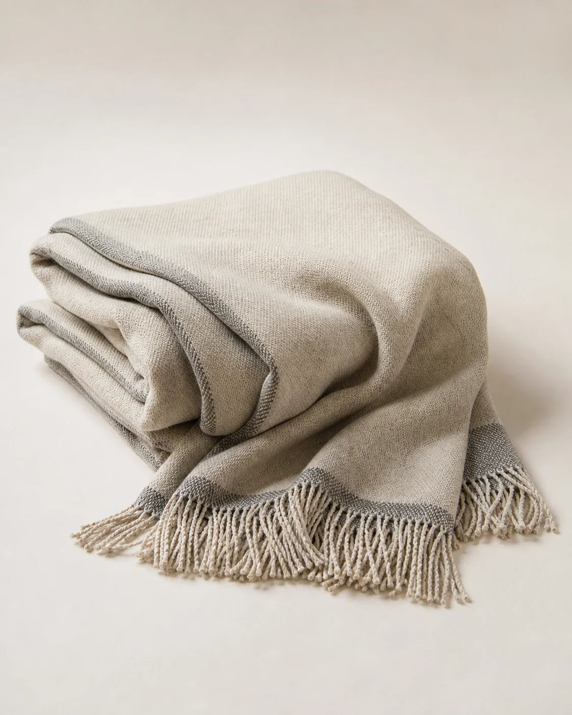 Ember Yak-Wool Throw by ALPORA, a warm yak-wool throw in earth brown and smoke, finished with a narrow charcoal edge